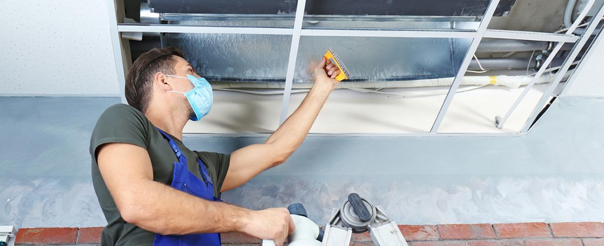 worker cleaning ventilation system